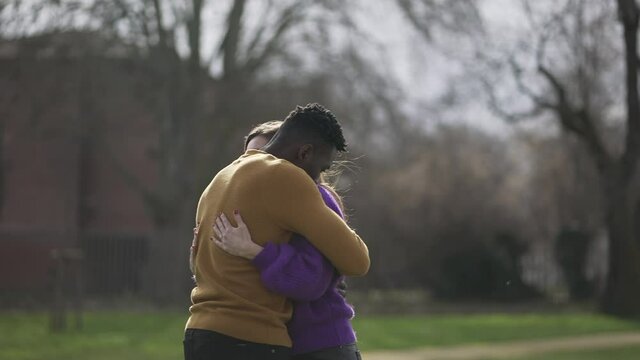 Interracial couple empathic embrace. Young woman romantic connection with partner outside