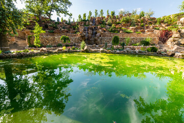Artificial pond or lake with a cascading fountain on a botanical park