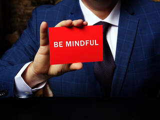 Business concept about BE MINDFUL with phrase on the sheet. Conceptual photo showing paying close attention to or being especially conscious of something