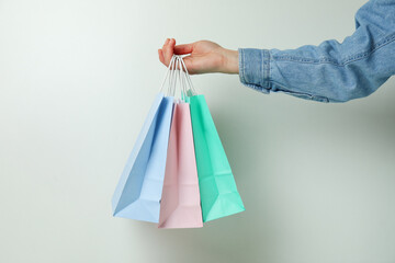Female hand hold paper bags on white background