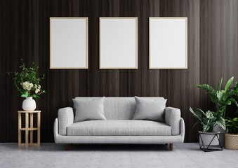 Living room with picture frame on the dark wood wall is beautiful, decorated with sofa and trees on the floor side.3d rendering.