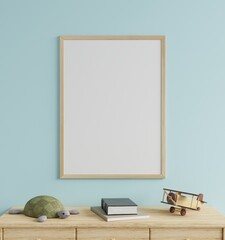 Mock up photo frame in the children's room on a blue wall, decorated with a tortoise doll and a wooden plane on the table.3d rendering.