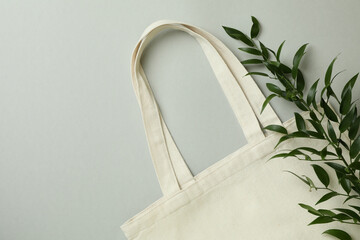 Eco bag and twig on light gray background