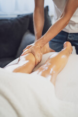 Professional masseur doing therapeutic massage. Woman enjoying massage in her home. Young woman...