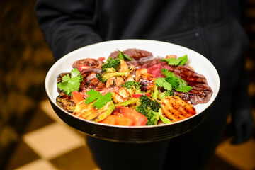 Grilled Beef Steak BBQ with roasted vegetables. Tasty meal for dinner, served by waiter in restaurant or diner.