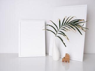 Mock up simply and modern white poster  frames two size decoration with dry leave in white vase on  white table and cement wall background