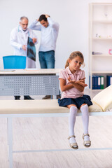 Fototapeta premium Small girl with her father visiting old male doctor radiologist