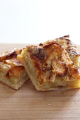 pieces of homemade apple pie with cinnamon on wooden board