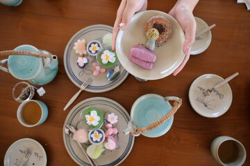 Hot tea and Thai style dessert on the wood table beside the wood wall. Cafeteria concept