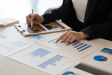 Financial Businesswomen analyze the graph of the company's performance to create profits and...