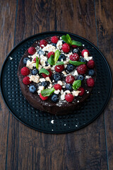 Chocolate Raw Cake with Raspberries, Blueberries, Meringue and Mint Leaves.