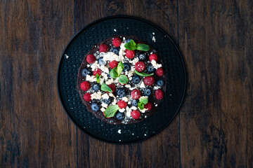 Chocolate Raw Cake with Raspberries, Blueberries, Meringue and Mint Leaves.