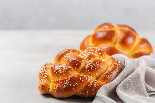 Homemade rose braid bread with sesame seeds. Light grey background, copy space.