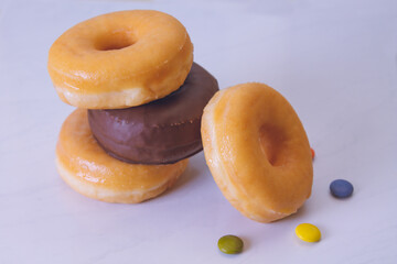 delicious sugary donuts on marbled white background
