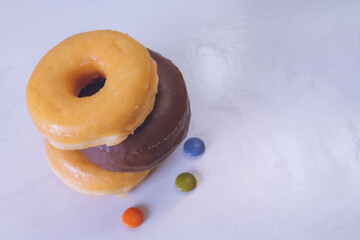 delicious sugary donuts on marbled white background