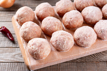 Frozen meatballs on a cutting board on a table