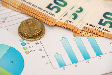 Euro coin and bills with calculator on chart with stock market prices.