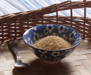 Brown cane sugar in a blue bowl close-up