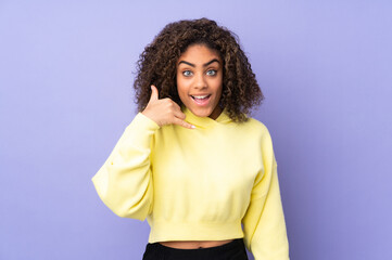 Young African American woman isolated on background making phone gesture. Call me back sign