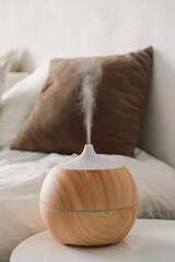 Aromatherapy Concept. Aroma oil diffuser on chair against in the bedroom. Air freshener.
