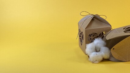 cotton flower packed in a gift box with hearts on a yellow background © Józef