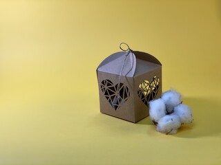 cotton flower packed in a gift box with hearts on a yellow background