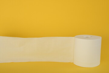Roll of toilet paper on yellow background.