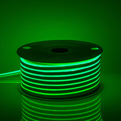 Flexible green glowing LED neon strip on black background.