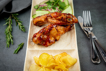European dish. Chicken in sauce, with fried potatoes and cucumber salad, herbs and onions. dark...