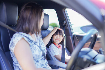 お母さんと車に乗る小さな女の子