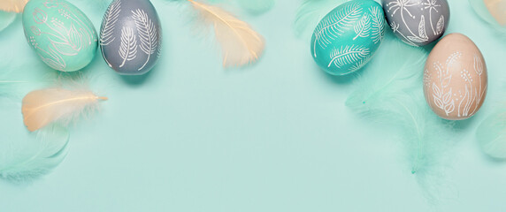 Happy easter minimal banner. Easter eggs and feathers on turquoise pastel background. Flat lay, copy space