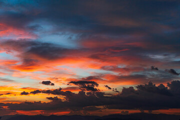 Evening dramatic sunset sky with bright rays of the sun and beautiful colorful clouds.