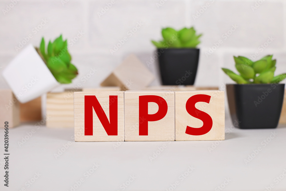 Poster nps as net promoter score. conceptual image. text on wood cubes. text in black letters on wood block