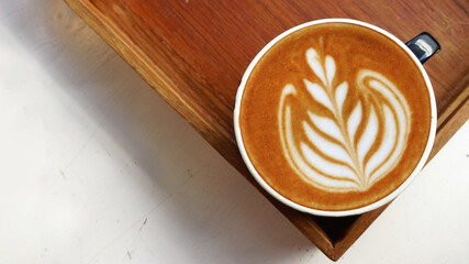 a cup of latte art coffee on wooden background                                                                                                                             