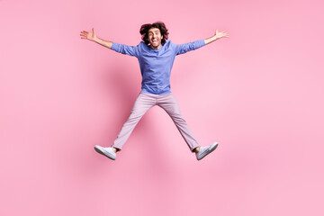 Fototapeta na wymiar Full size photo of young handsome excited happy smiling positive cheerful man jump fly isolated on pink color background