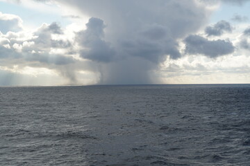 Obraz premium Storm over the sea with heavy rainfall and snow clouds observed on Pacific ocean in winter time.