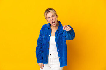 Young Russian woman isolated on yellow background frustrated and pointing to the front