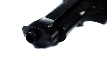 Barrel of a black gun, pistol lies on a white background. Close up.