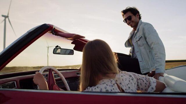 Tracking video of happy man jump in red convertible. Shot with RED helium camera in 8K.