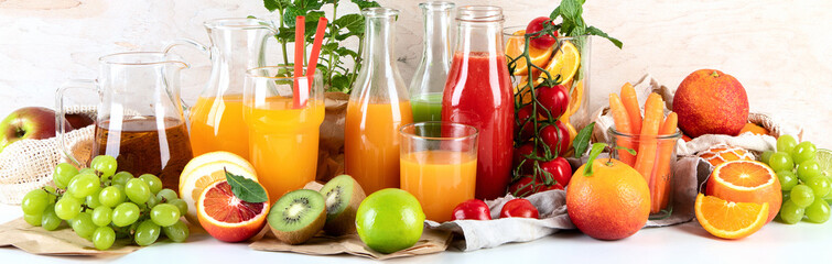 Healthy home made juices and fruits on light wooden background