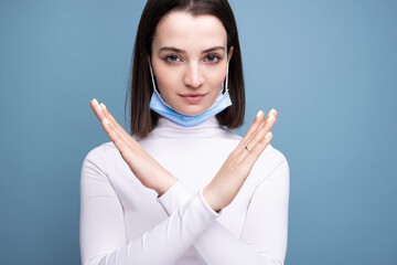 A young girl put on a medical mask incorrectly. The woman shows an error while wearing a mask.