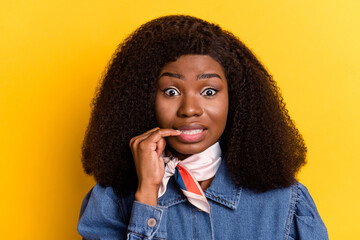 Photo of questioned dark skin lady teeth biting finger nail look camera isolated on yellow color...