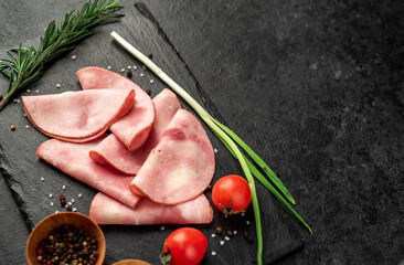Sliced ​​ham on a stone background with copy space for your Fresh prosciutto text.