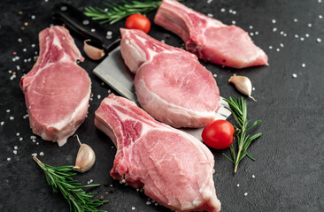raw pork steaks on stone background