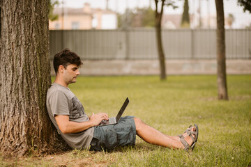 Obraz premium Man working outdoors with laptop. Technology and telecommuting concept.