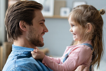 Portrait of handsome father and his cute daughter hugging and smiling.
