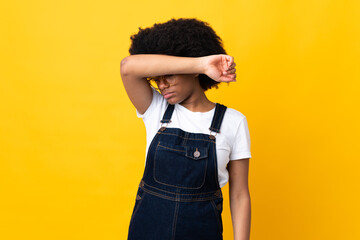 Young African American woman isolated on yellow background covering eyes by hands