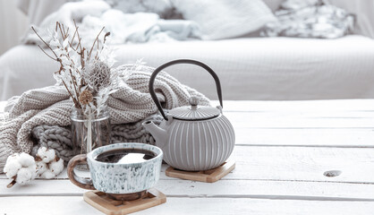 Cozy Scandinavian composition with teapot, ceramic cup of tea and decor details copy space.