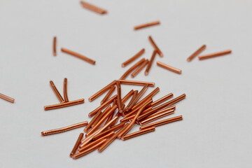 pieces of copper wire are scattered across the white background