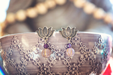 Lotus earrings with mineral stone beads hanging on decorative background